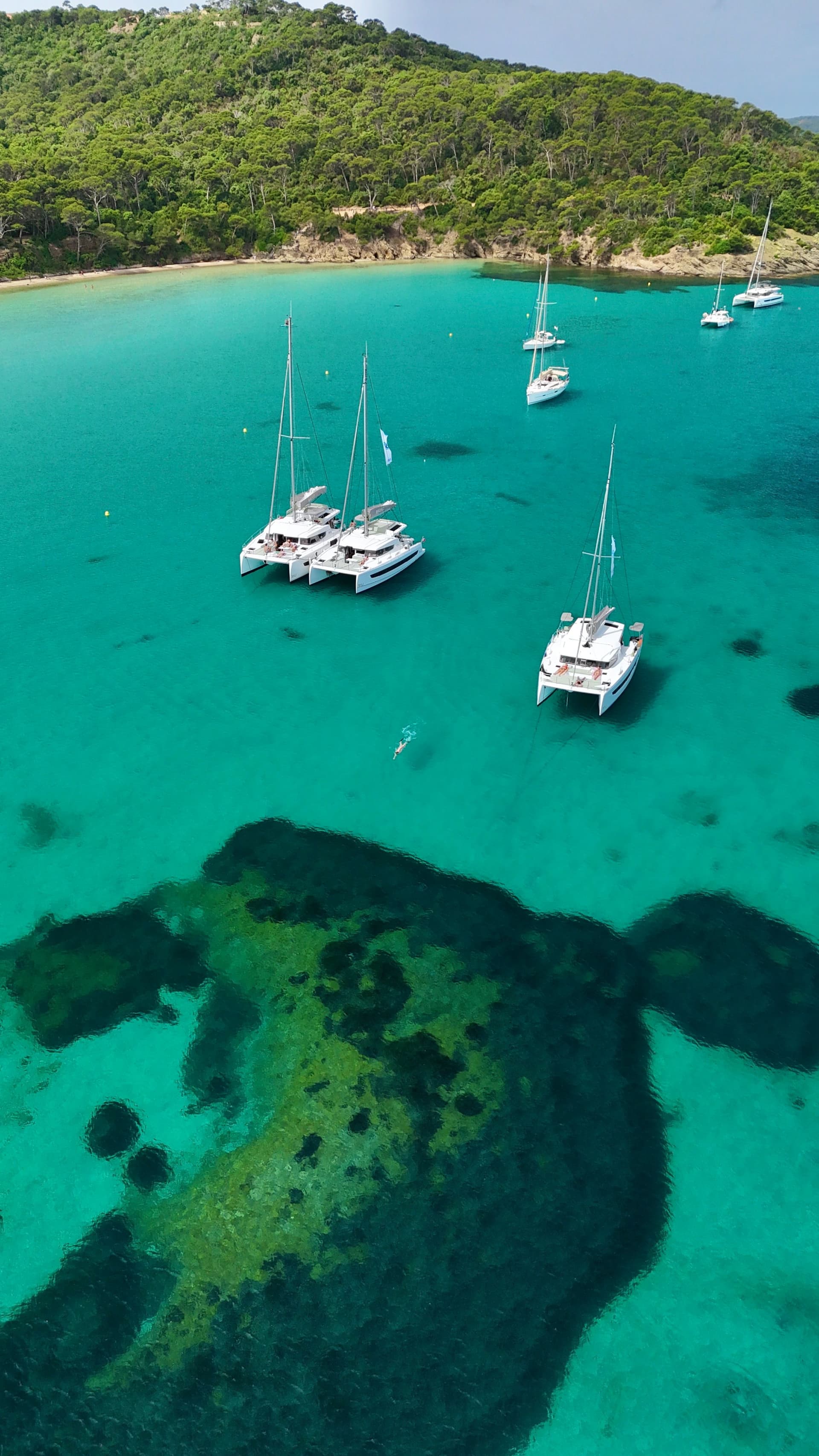 3 bateaux à voile bali catamaran au mouillage devant 