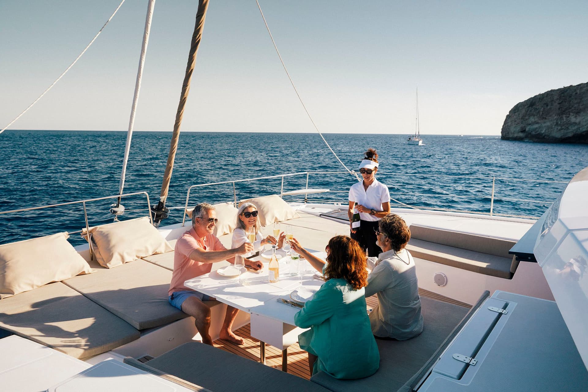 Deux couples dinant et trinquant sur la table du pont avant