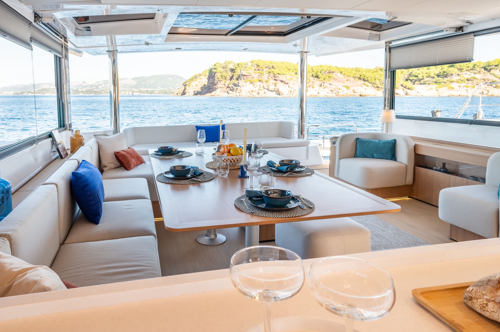 Table du carré dressée avec porte basculante ouverte sur la mer