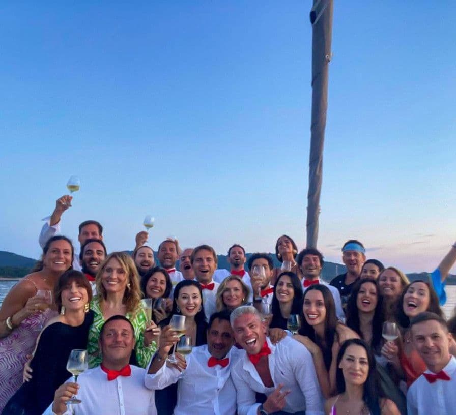 groupe d'amis hommes et femmes réunis au coucher du soleil à bord d'un bateau